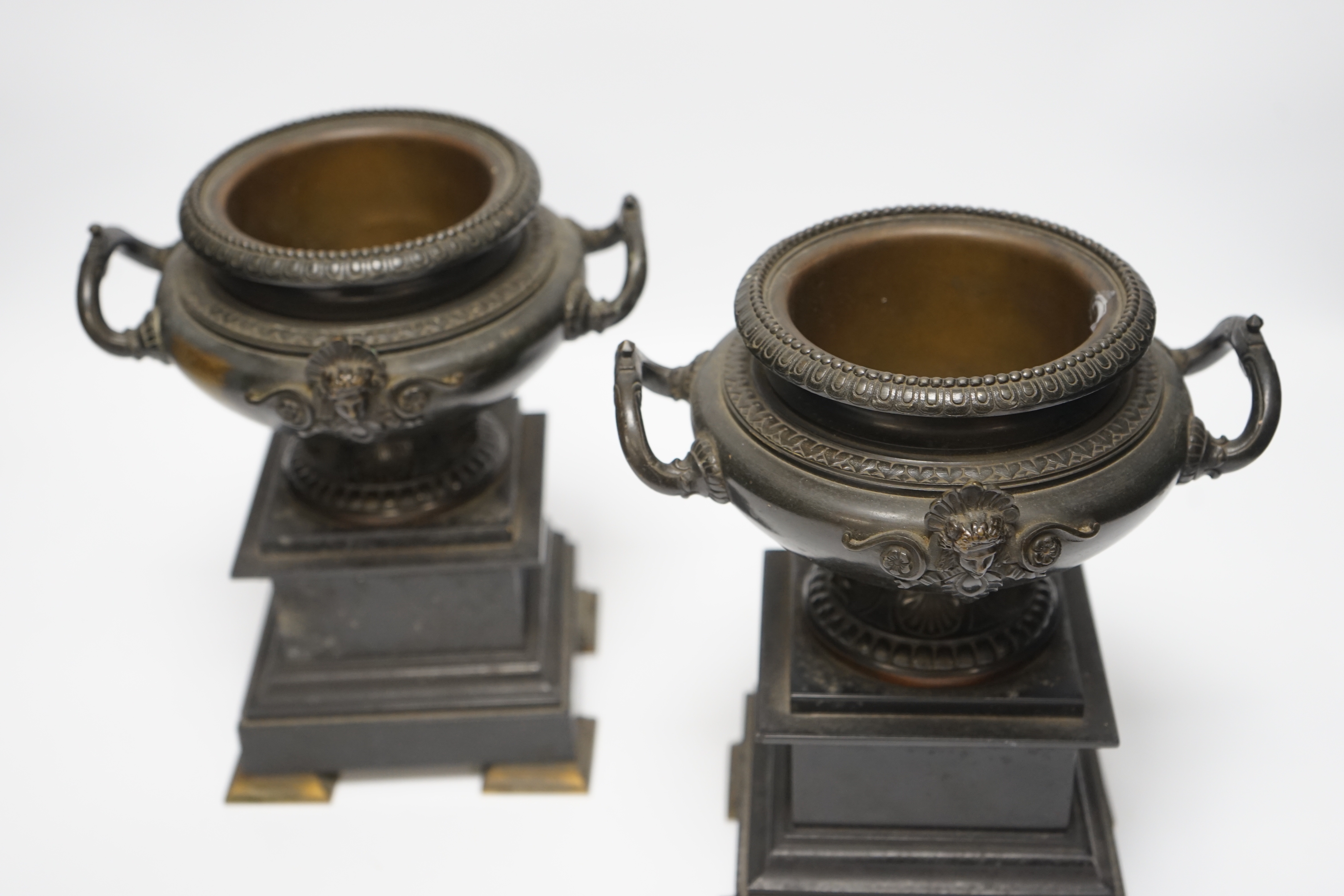 A pair of 19th century bronze urns on slate pedestals, 21.5cm high